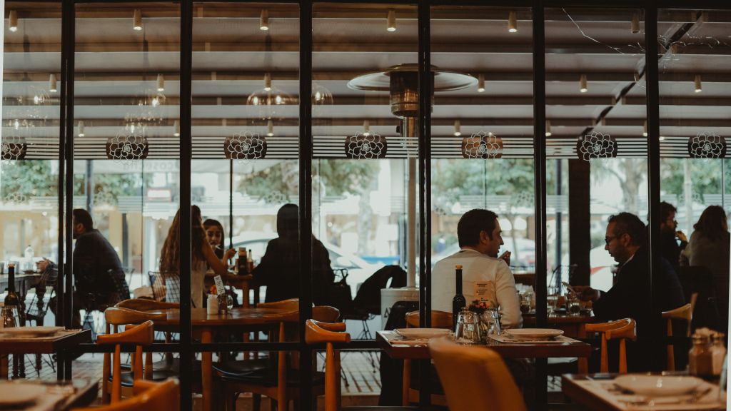 Busy restaurant dining room during a packed Friday evening service with warm lighting and full tables