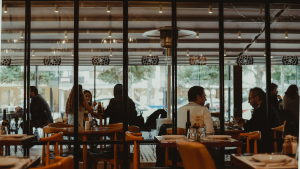 Busy restaurant dining room during a packed Friday evening service with warm lighting and full tables