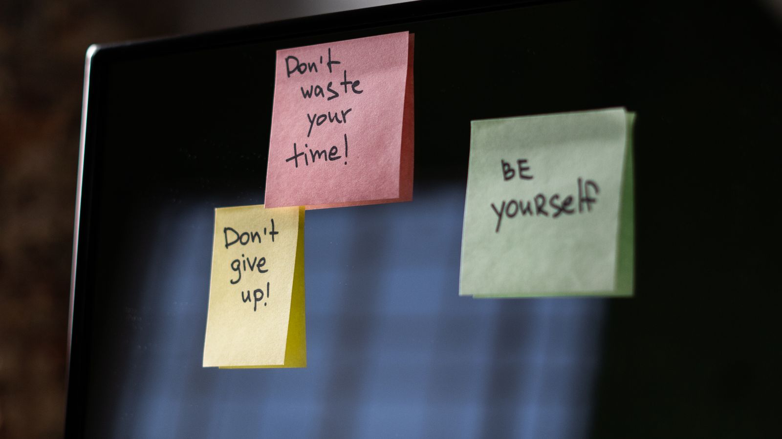 Sticky notes stuck around a computer screen, the written-down passwords a Cyber Essentials password policy is designed to stop